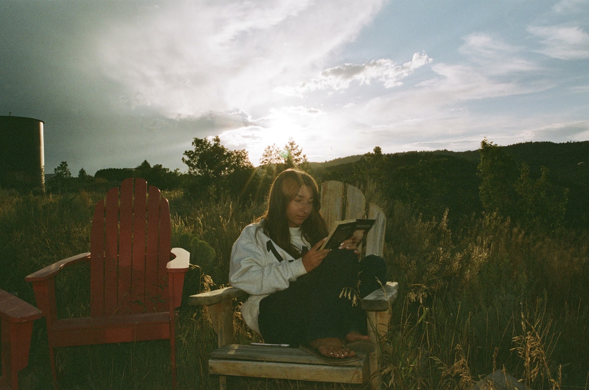 Audrey Fox reading outdoors at sunset